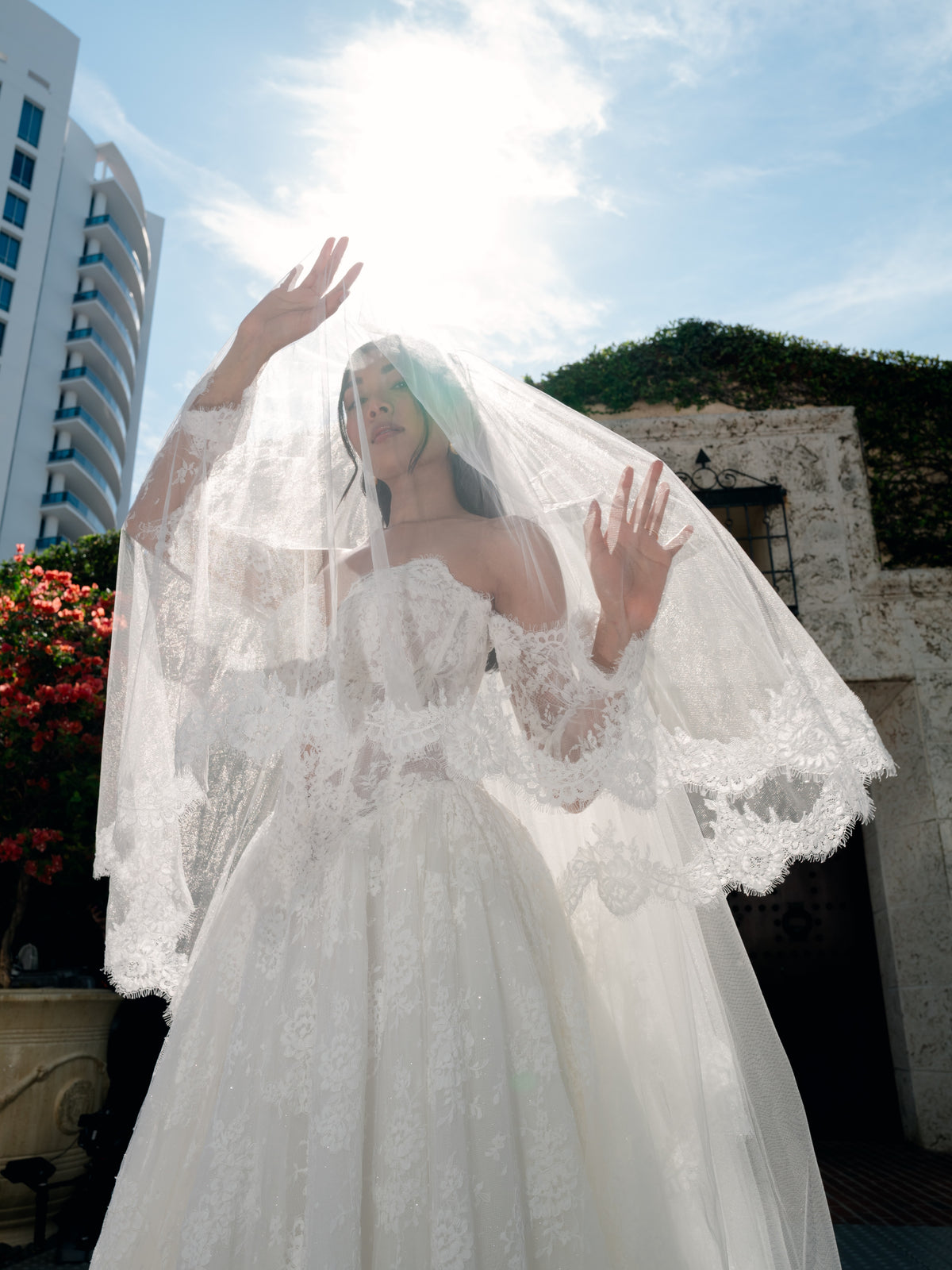 Ball gown in corded lace with sweetheart neckline and lace up back closure. Long detachable lace sleeves. Long veil with 2 tiers finished with scallop edge all over hemline.