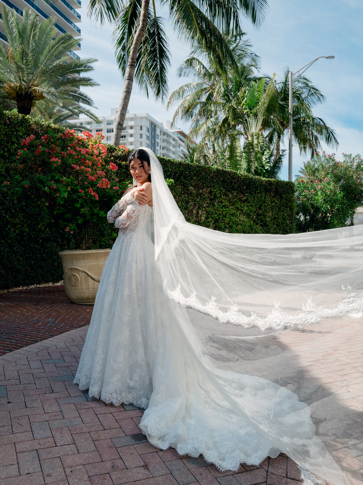 Ball gown in corded lace with sweetheart neckline and lace up back closure. Long detachable lace sleeves. / Long veil with 2 tiers finished with scallop edge all over hemline.