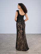 Woman wearing a black lace evening gown against a plain background / Slim style in all over delicate lace with V-neck, decorated with beaded lace motifs. Low scoop back.