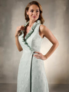 Woman wearing a light green dress against a neutral background / Sleeveless floral jacquard A-line with high ruffled collar.