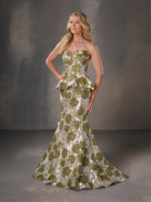 Woman wearing a strapless green and white patterned gown against a gray background / Strapless floral brocade peplum fit & flare gown.