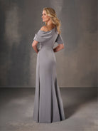 Woman wearing a gray off-shoulder gown against a gray background / Stretch charmeuse slim A-line with asymmetrical neckline and off-shoulder sleeve on one side.