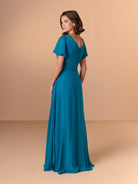 Woman wearing a teal evening gown against a beige background / A-line chiffon style with V-neck and short flatter sleeves. Finely gathering on bodice finished with hand beading motif on side waist area.