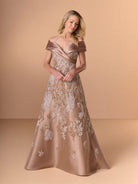 A woman models an off-the-shoulder A-line evening gown in a champagne beige satin fabric with white floral embroidery, set against a solid warm beige studio background. / A-line lace dress with mikado collar off-shoulder.