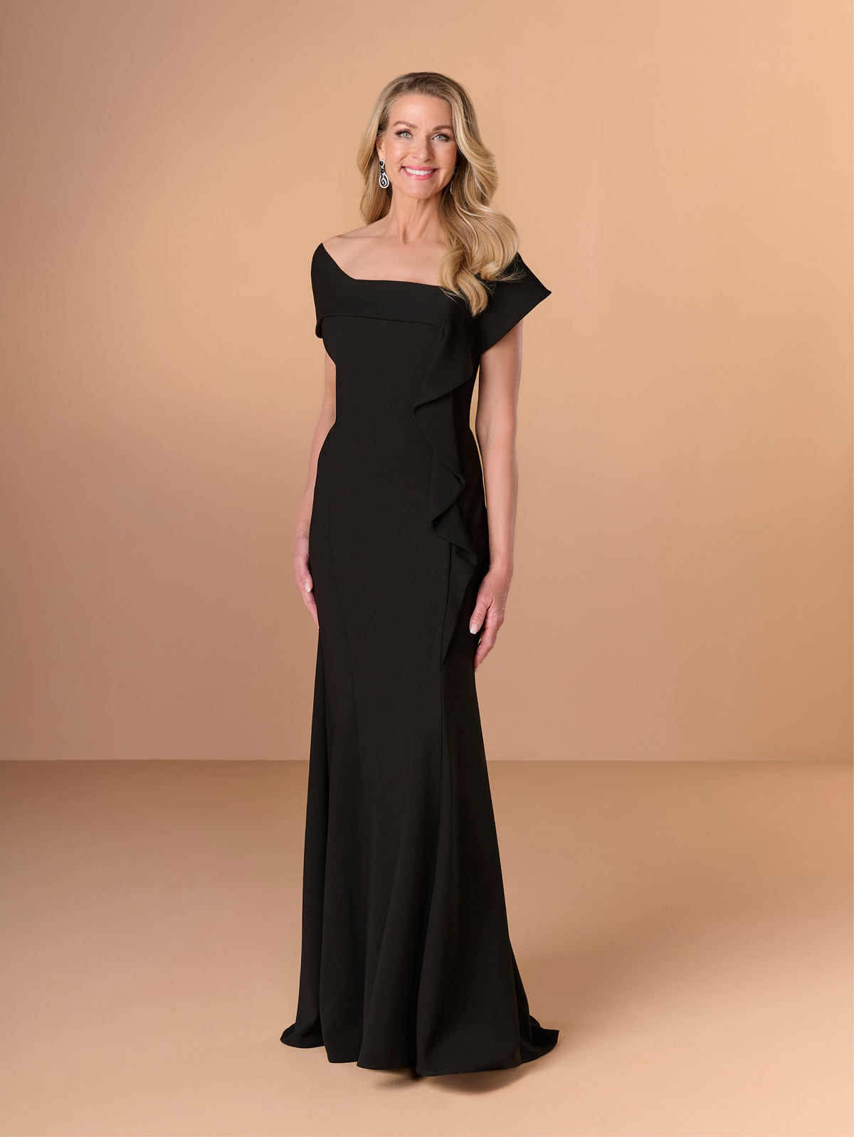 Woman wearing a black one-shoulder dress against a beige background / Slim crepe style with asymmetrical wide collar and side raffle.