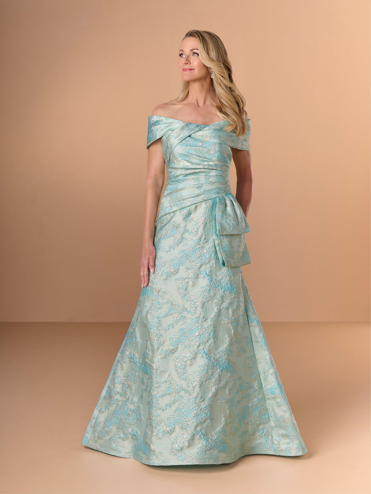 Woman wearing a light blue off-shoulder gown with floral patterns against a beige background / Slim jacquard style with collar/straps twist, pleating on front bodice.