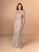 Woman wearing a silver off-shoulder evening gown against a beige background / Slim lace style with straight neckline and wide off shoulder collar. Split on center back skirt.