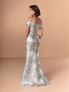 Woman wearing a silver off-shoulder gown against a beige background / Slim brocade style with sweet off-shoulder neckline, short sleeves, draping on stomach area.