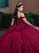 This ball gown features a richly embroidered bodice with off-the-shoulder straps. The full, voluminous skirt is decorated with shimmering floral detailing and flows into an elegant train accented with a bow at the back.