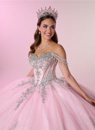 A smiling young woman wearing a sparkling off-the-shoulder pink quinceañera ball gown with silver beaded embroidery, a matching tiara, and a necklace, posed against a solid pink studio background. / Enchanting ball gown with sparkling embroidery, an off-shoulder neckline, and a voluminous skirt finished with a dramatic oversized bow at the back.