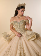 A woman wearing an ornate off-the-shoulder ball gown in champagne beige with intricate gold embroidery, a matching tiara, and a gold necklace, posed against a warm beige studio background. / Opulent off-shoulder ball gown featuring intricate embroidered appliqués, dramatic tiered draping, a structured corset bodice, and a sweeping cathedral-length train.