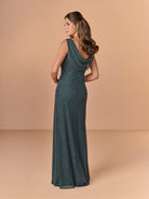 Woman wearing a long, dark green dress with a cowl neckline against a beige background / All over beaded gown with body shirring and back cowl neckline.