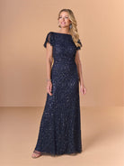 Woman wearing a navy blue sequin gown against a beige background / All over crunchy bead gown with flutter sleeve and cowl back.