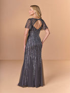 Woman wearing a long, dark blue evening gown with lace details on a beige background / All over beaded gown with v neckline, long flutter sleeve and slim, soft godet skirt.