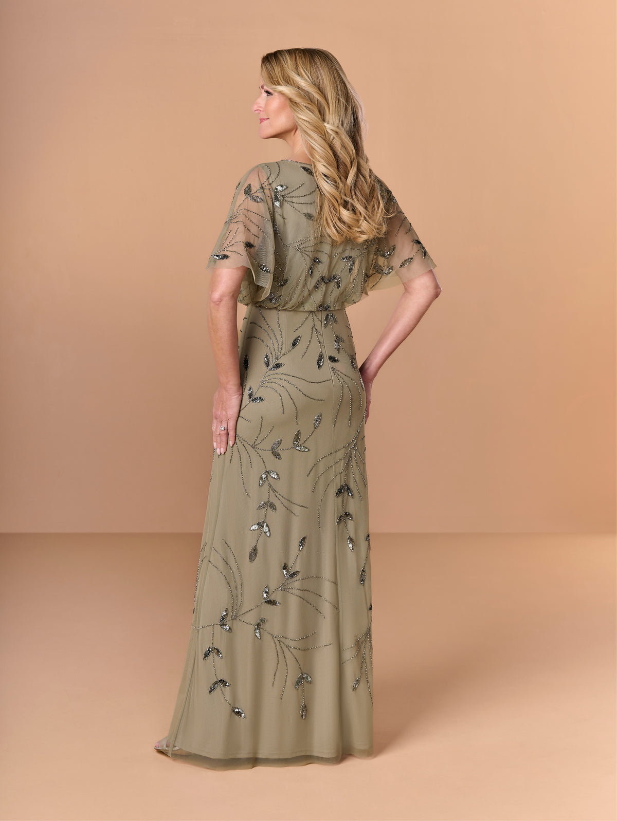 Woman wearing a long, olive green dress with floral patterns against a beige background / All over beaded gown with surplice, blouson bodice and soft A-line skirt.