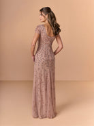 Woman wearing a long, elegant dress with floral patterns on a beige background / All over beaded gown with scoop neck and short sleeve.