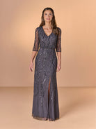 Woman wearing a dark gray lace evening gown with a V-neck and quarter sleeves on a beige background / All over beaded gown with v neckline, blouson bodice and slim slit skirt.