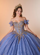 A woman wearing an off-the-shoulder light blue ball gown with ornate gold embroidery, a matching blue bow on the sleeve, and a gold tiara, posed against a warm beige studio background. / An off-the-shoulder ball gown with ruffled cap sleeves, a heavily embroidered metallic bodice, and a voluminous glitter-tulle skirt adorned with intricate baroque-style appliques and a matching oversized back bow.