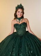 A woman wearing a voluminous dark green quinceañera ball gown with sequined floral appliqué, a matching green choker necklace, and a green tiara, posed against a warm beige studio background. / A strapless sweetheart ball gown featuring a fully beaded corset bodice, a lace-up back, and a voluminous tulle skirt layered with shimmering sequin floral details and an oversized back bow, paired with a matching beaded choker necklace.