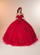 A young woman wearing a voluminous off-the-shoulder red quinceañera ball gown with floral lace applique and a matching red tiara, posed against a warm beige studio backdrop. / Ball gown with a lace-detailed back, corset lacing, and a large bow at the waist. The full skirt has a subtle sparkle and elegant embroidery.