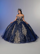 A woman modeling an elaborate off-the-shoulder ball gown in deep navy blue with intricate gold floral lace embroidery, set against a studio backdrop with a blue-to-gray gradient. / Elegant off-shoulder ball gown featuring intricate embroidered detailing, a structured bodice, and a voluminous skirt with a dramatic statement bow at the back.