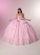 A young woman wearing a voluminous light pink ball gown with a strapless sweetheart bodice, heavy beading, and a very full layered tulle skirt, posed against a soft pink-to-white studio backdrop. / Fairytale ball gown featuring a crystal-embellished corset bodice, elegant cape sleeves, dramatic layered skirt details, and a voluminous silhouette finished with a statement bow and sweeping train.